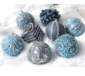 Close-up of festive sky blue and navy Christmas ornaments on a snowy winter background