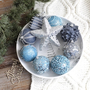 Blue and silver Christmas ball ornament set with glitter stars on a white knit blanket