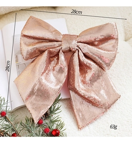 Close-up of 28cm rose gold sequin bow ornament for Christmas tree decor on white plush