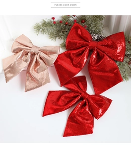 Detailed view of red and champagne glitter Christmas bows on pine branches