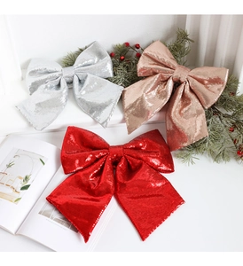 Close-up of sparkling sequin Christmas bows in silver, gold, and red for festive decor