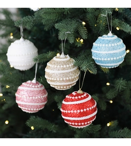 Detailed view of 8cm glitter Christmas baubles with white pearls on a festive pine tree