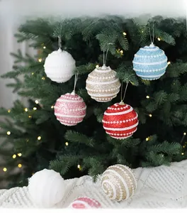 Close-up of glittery 8cm Christmas ball ornaments with pearl beads on a festive tree
