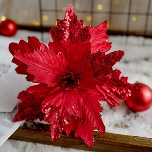 Poinsettia natalizia in velluto con paillettes rosse su sfondo invernale e luci