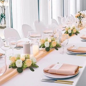 Centro de mesa de boda con rosas artificiales blancas y champán y portavelas
