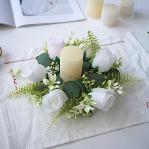 Detalle de corona de rosas blancas y rosas para velas con hojas de eucalipto