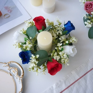 Primer plano del anillo de vela con rosas artificiales rojas blancas azules y hojas