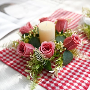 Detalle de corona de vela con rosas rosadas artificiales y hojas de eucalipto