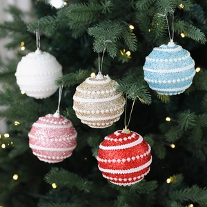 Five colored 8cm foam Christmas balls with glitter and pearls hanging on a tree