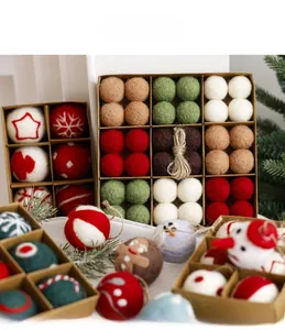 Detail of wool felt Christmas ball ornaments set in a kraft box with festive greenery
