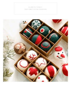 Close-up of wool felt Christmas ornaments with snowman and gingerbread motifs in a gift box
