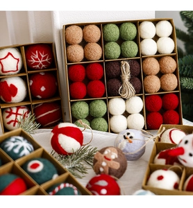 Detailed view of wool felt Christmas ornaments with embroidery patterns in a kraft paper box