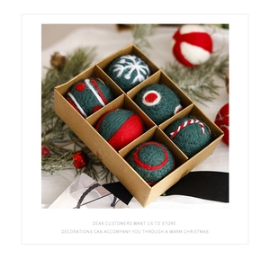 Detailed view of handmade wool felt Christmas ornaments with embroidery in a craft box
