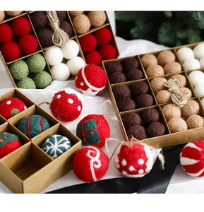 Macro shot of assorted festive wool felt Christmas balls with snowflake motifs in a gift box