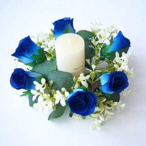 Corona de velas con rosas azules artificiales y hojas verdes de eucalipto