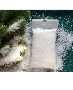 Detail van kunstmatige sneeuwpoeder op kerstboomtakken met feestelijke verpakking