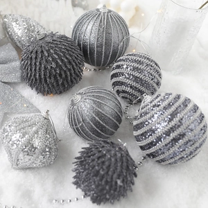 Silver-grey Christmas ball ornaments set with diverse textures on snowy background