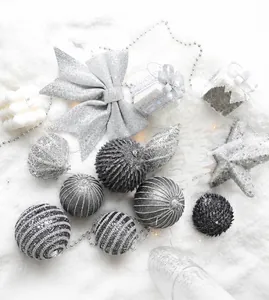 Silver Christmas ornaments with glitter bows and stars on white artificial snow background