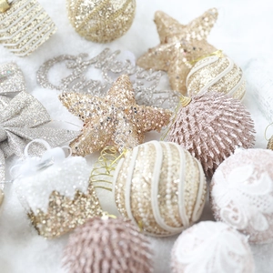 Coffret de boules et étoiles de Noël dorées et blanches sur fond de neige artificielle