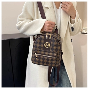 Detailansicht eines braunen Lederrucksacks mit goldenem M-Logo und Rautenmuster
