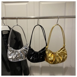 Three pleated metallic shoulder bags in silver, black, and gold on hangers