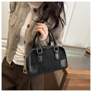 Dettaglio della borsa Boston vintage con mix di pelli e logo MTN in rilievo