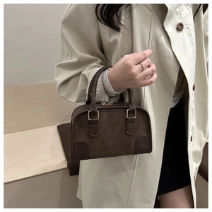 Dettaglio borsa Boston in camoscio marrone con goffratura DTN e cuciture in pelle