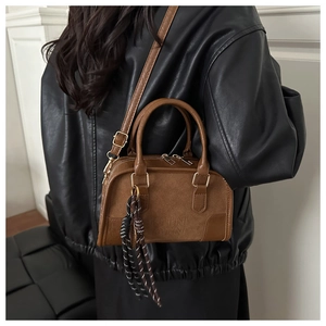 Dettaglio della borsa Boston vintage in pelle marrone con inserto in camoscio e logo