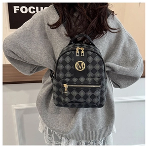 Details eines grauen gesteppten Mini-Rucksacks mit goldenem M-Logo und Muster