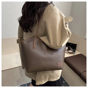 Macro detail of dark brown lychee leather texture and FASHION & BAGS logo on the tote bag