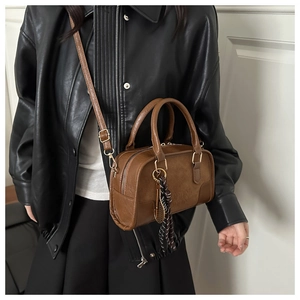 Borsa Boston vintage marrone con catena e logo indossata da una modella