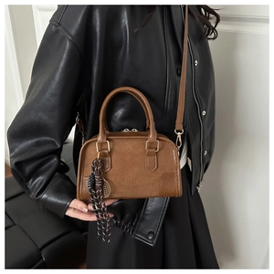 Dettaglio della borsa Boston in pelle marrone con logo in rilievo e finitura testurizzata