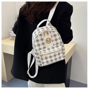 Detail eines weißen Stepp-Minirucksacks mit goldenem M-Logo und verstellbaren Gurten