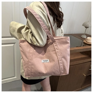 Pink corduroy tote bag detail featuring the Fashion Instinct label and soft ribbed texture