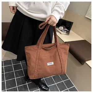Detail of brown corduroy tote bag with soft ribbed texture and Fashion Instinct label