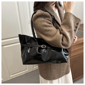Glossy black PU leather tote bag styled with a brown herringbone blazer and white dress