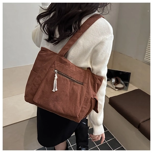 Détail du sac fourre-tout en velours côtelé marron avec poche zippée et large bandoulière