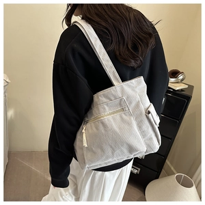 Détail du sac fourre-tout en velours côtelé crème avec texture côtelée et poche à rabat