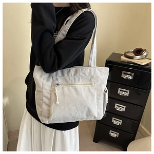 Détail du sac cabas en velours côtelé avec texture et poche avant zippée et cordon