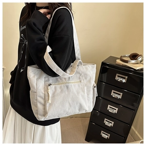 Détail du sac fourre-tout en velours côtelé crème avec poche zippée et rangement latéral