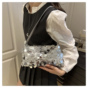 Detailed view of silver sequin shoulder bag on model showing size and metallic finish