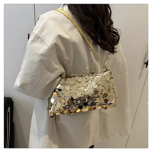 Dettaglio della borsa a tracolla con paillettes dorate e trama di lusso con cinturino