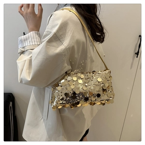 Detail of gold large sequin shoulder bag showing reflective texture on a model