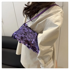 Detail view of purple sequin evening bag with sleek leather strap and rectangular body