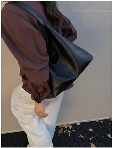 Detail of black leather shoulder bag with FASHION & BAGS LEATHER print on side