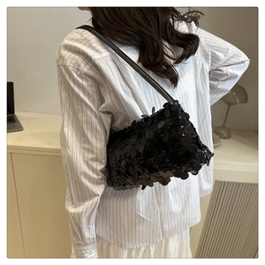 Close-up of black sequined shoulder bag on a model showing texture and fit