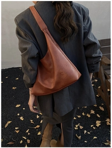 Detail of vintage brown leather hobo bag with Fashion & Leather embossed logo