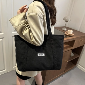 Fashionable black corduroy tote bag for women with minimalist shoulder strap design