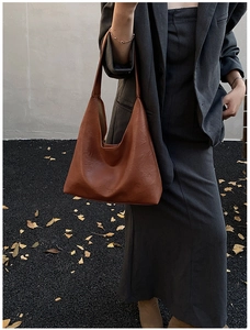 Close-up of vintage brown leather hobo bag with textured surface for autumn fashion