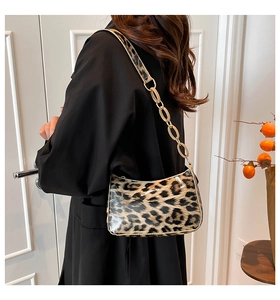 Detail of leopard print crescent bag with polished gold chain strap and glossy finish